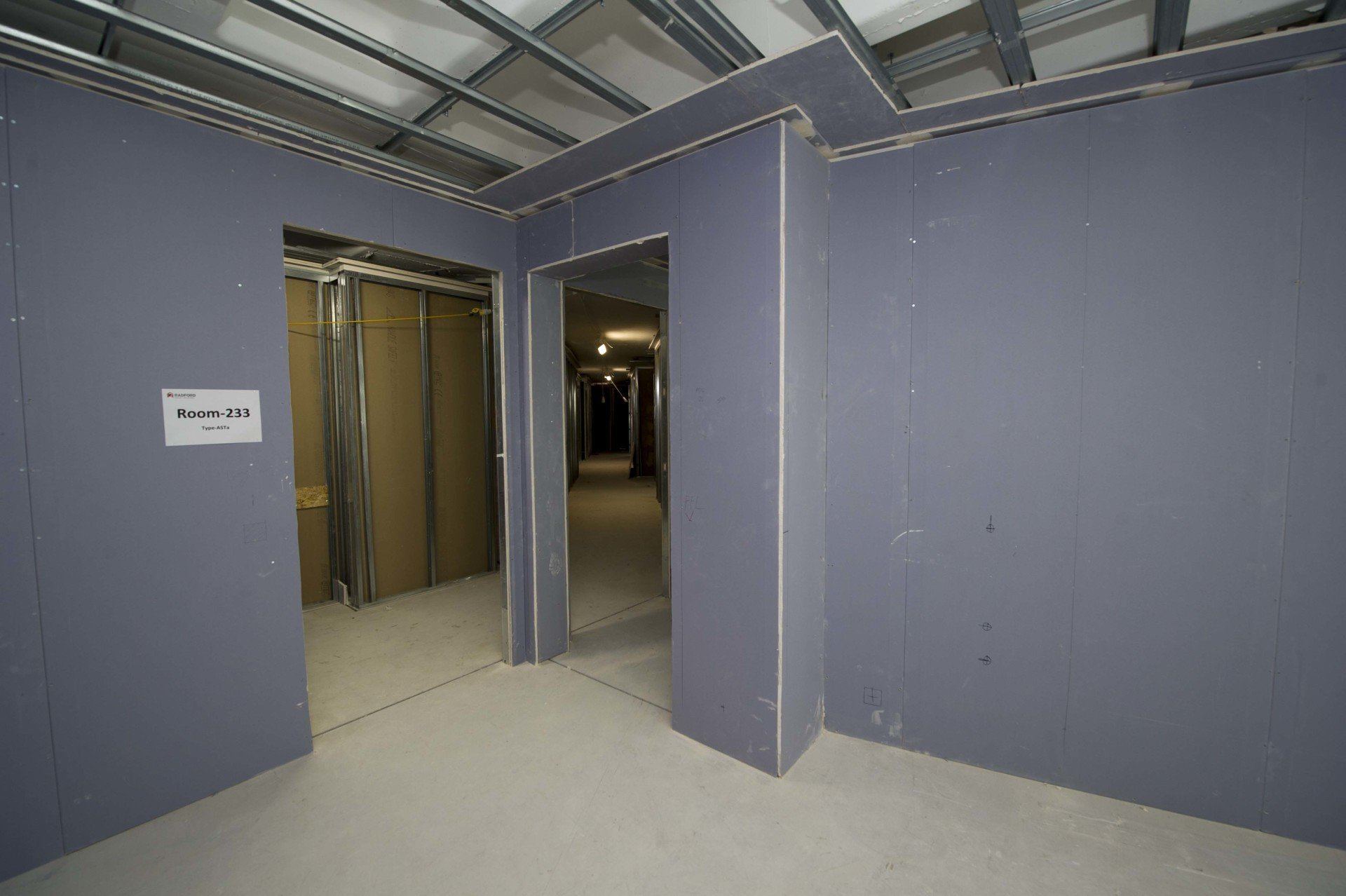 Dry-lined corridor with partition walls and suspended ceiling